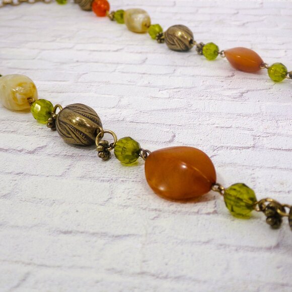 Multi color bead necklace with a mix of beige, green, and deep orange tones. - Picture 4 of 11